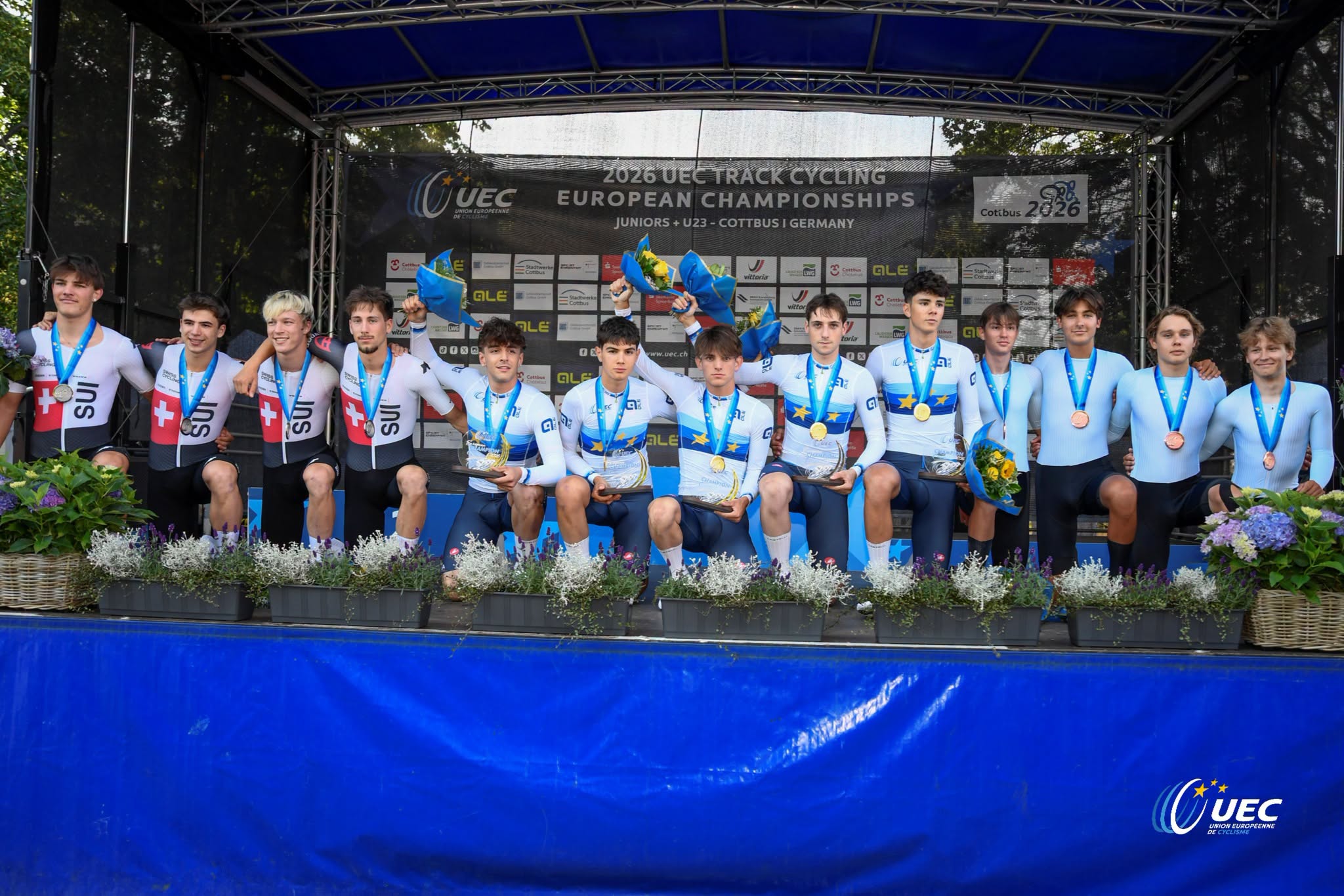 O pódio da Perseguição Individual dos juniores masculinos com Suíça, Itália e Atletas Individuais Neutros